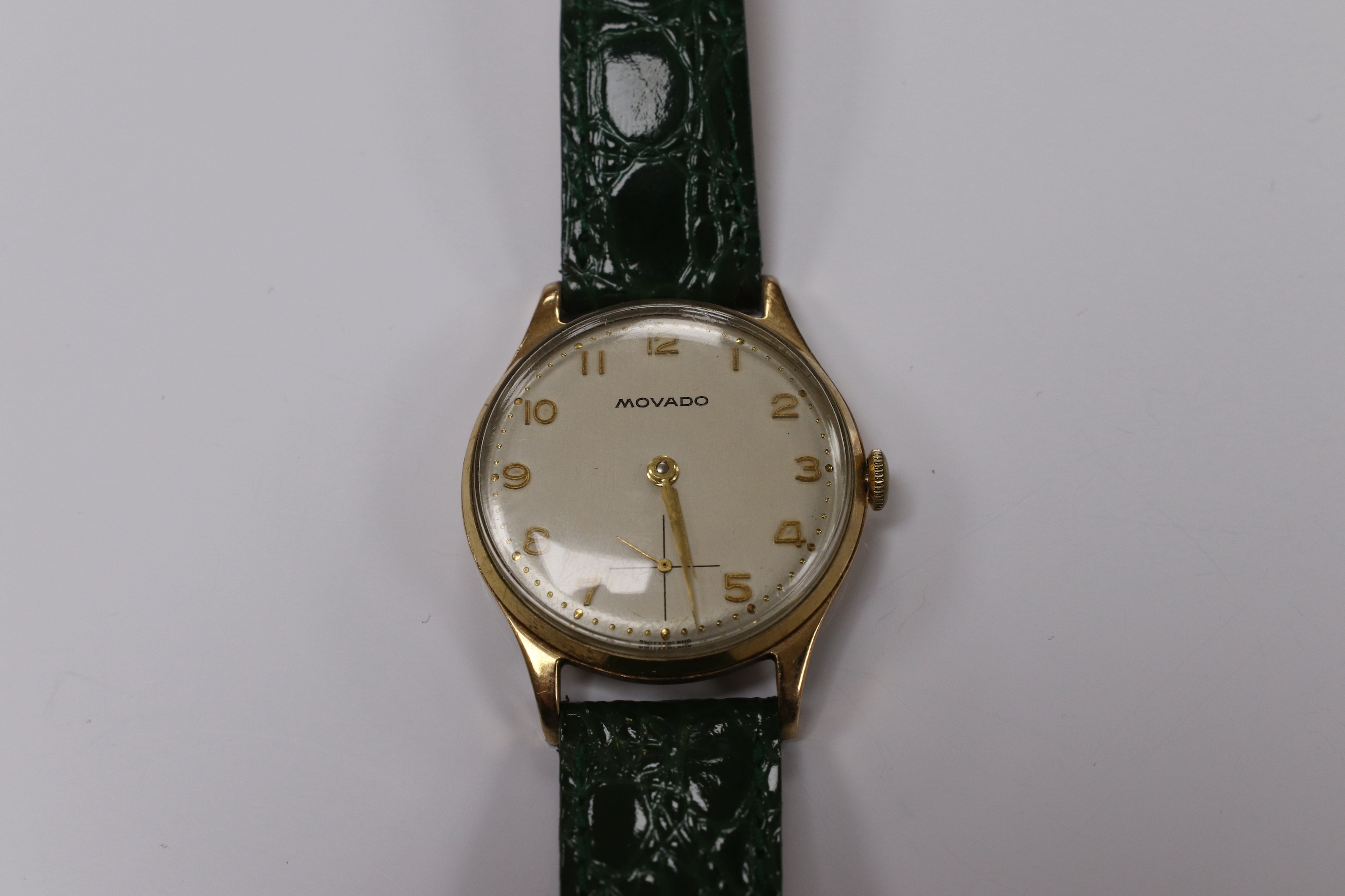 A gentleman's 1950's 9ct gold Movado manual wind wrist watch, with Arabic dial, subsidiary seconds and case back inscription, case diameter 31mm, on a later associated leather strap. Condition - fair